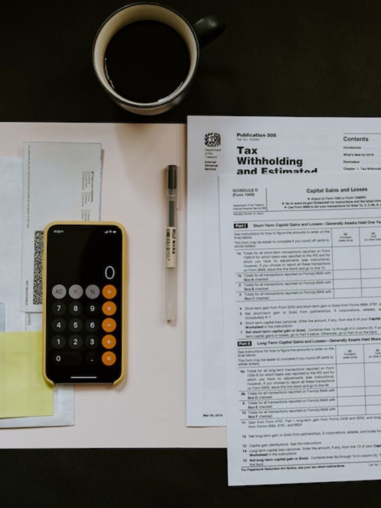 Coffee, a calculator, and other supplies as someone sits down to do their taxes