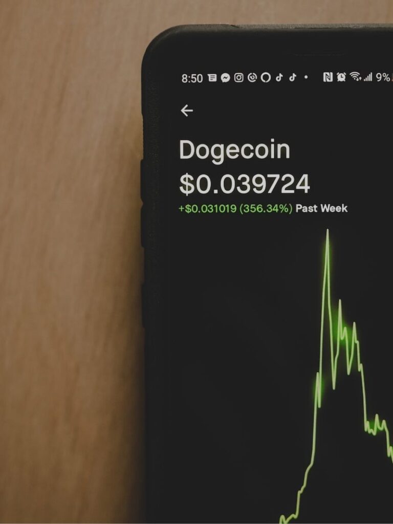 a phone shows a price chart of Dogecoin going up and crashing down again