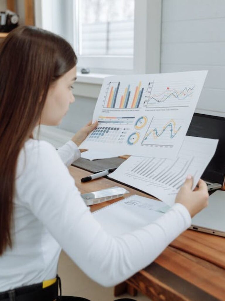 a woman looks at several colorful financial reports